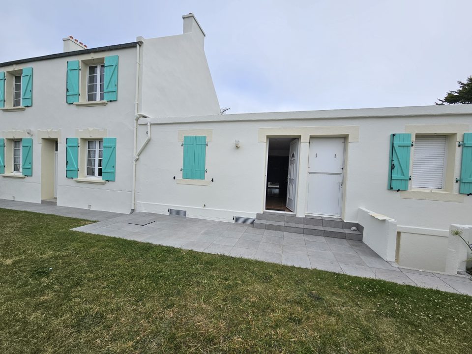 Façade de maison rénovée en blanc avec volets turquoise par Taloc Façades